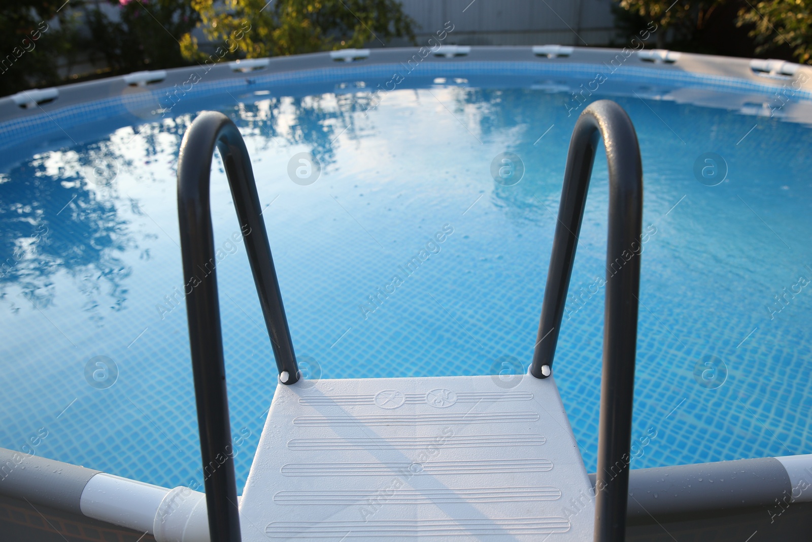 Photo of Above ground swimming pool with ladder outdoors, closeup