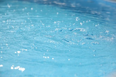 Photo of Clear water with ripples in outdoor swimming pool, closeup