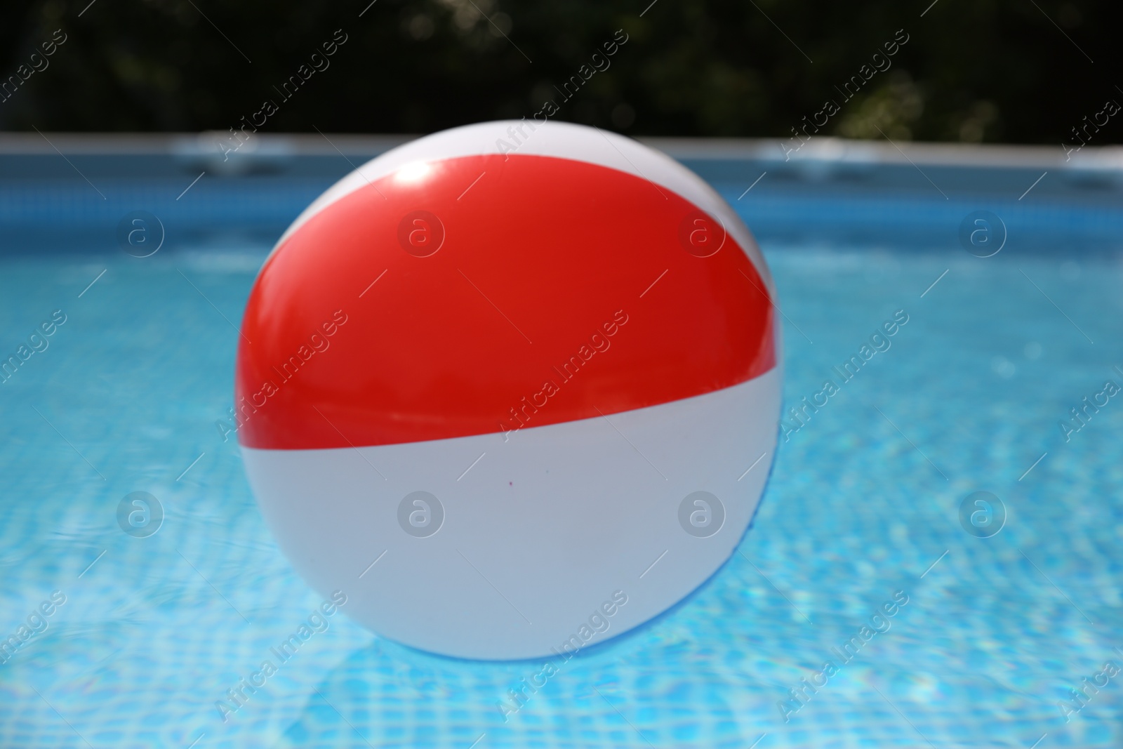 Photo of Inflatable ball in above ground swimming pool outdoors on sunny day