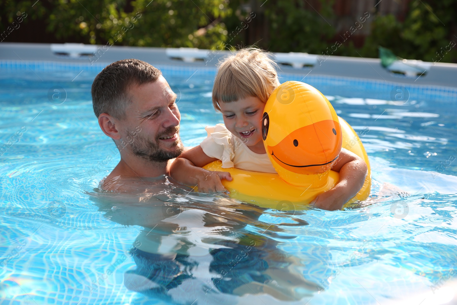 Photo of Happy father having fun with his daughter in swimming pool