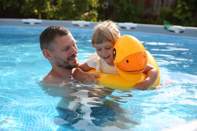 Happy father having fun with his daughter in swimming pool