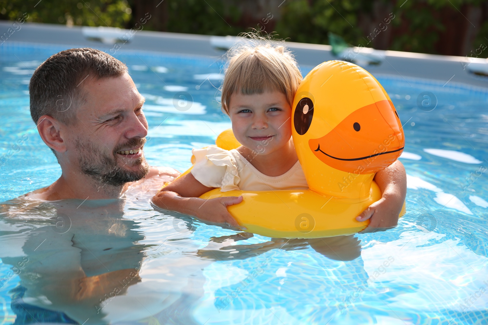 Photo of Happy father having fun with his daughter in swimming pool