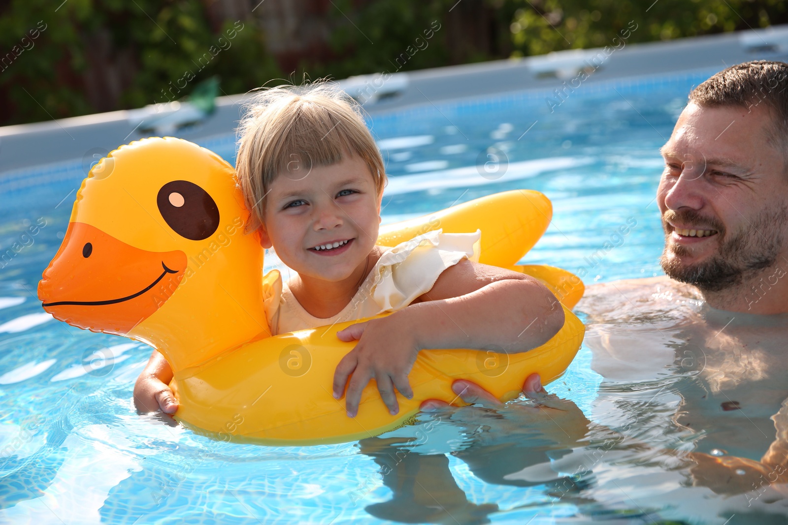 Photo of Happy father having fun with his daughter in swimming pool