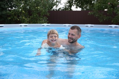 Happy father having fun with his daughter in swimming pool