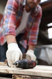 Photo of Man working with electric screwdriver outdoors, closeup