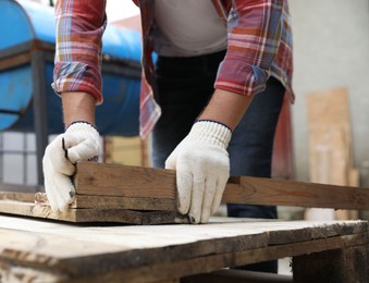 Photo of Man working with wood in backyard, closeup