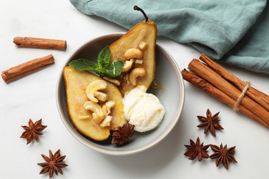 Photo of Delicious baked pears with nuts, ice cream, anise stars, cinnamon sticks, mint and honey on white table, flat lay