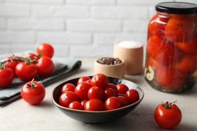 Tasty pickled tomatoes, fresh vegetables and spices on light grey table