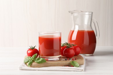 Tasty tomato juice with fresh vegetables and spices on white wooden table