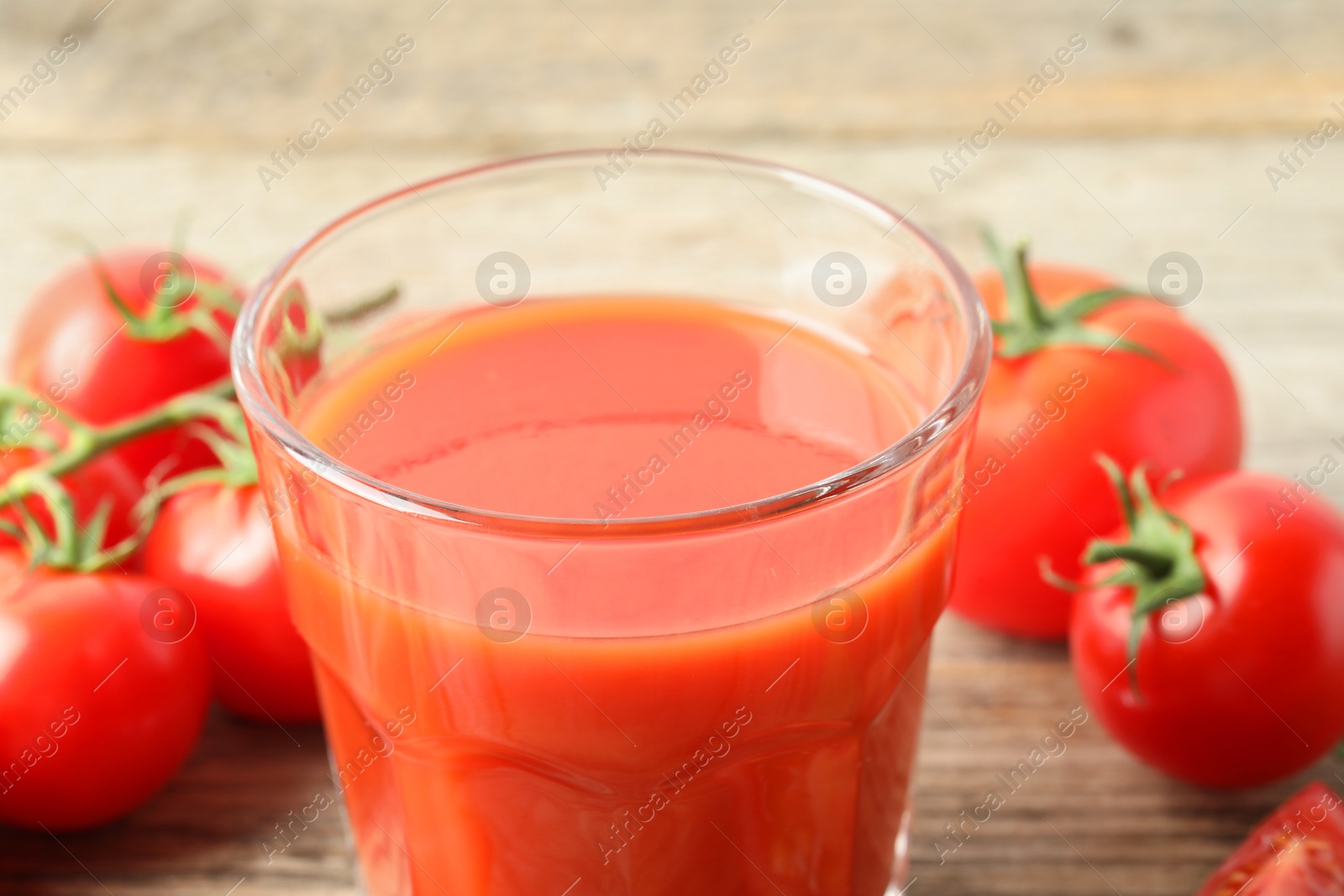 Photo of Fresh tomato juice in glass on table, closeup