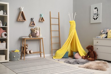 Stylish child room interior with modern furniture, toys and play tent