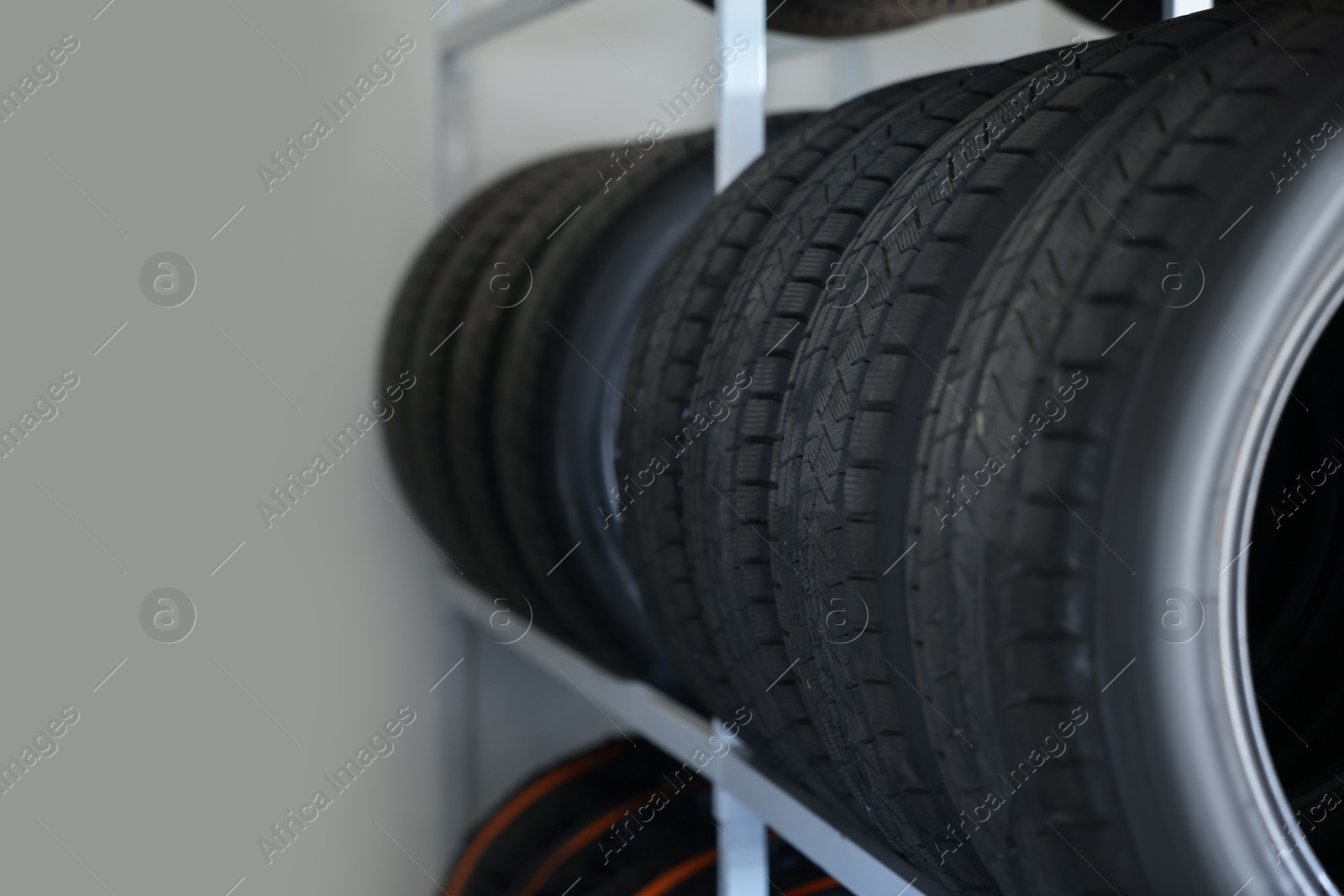 Photo of Group of car tires in auto store, closeup. Space for text