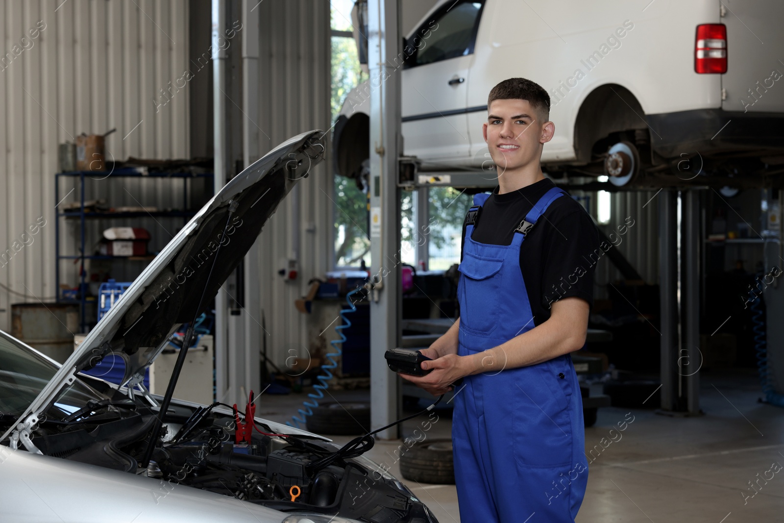 Photo of Young auto mechanic doing car diagnostic at automobile repair shop