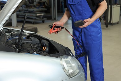 Photo of Auto mechanic fixing car at automobile repair shop, closeup