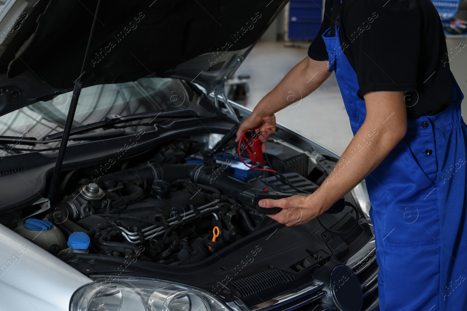 Photo of Auto mechanic fixing car at automobile repair shop, closeup