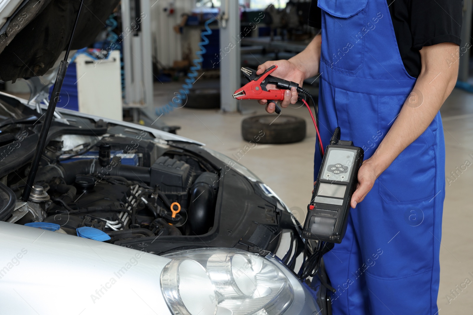 Photo of Auto mechanic fixing car at automobile repair shop, closeup