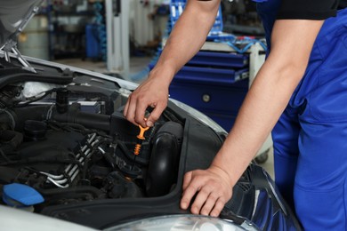 Photo of Auto mechanic fixing car at automobile repair shop, closeup