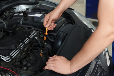 Photo of Auto mechanic fixing car at automobile repair shop, closeup