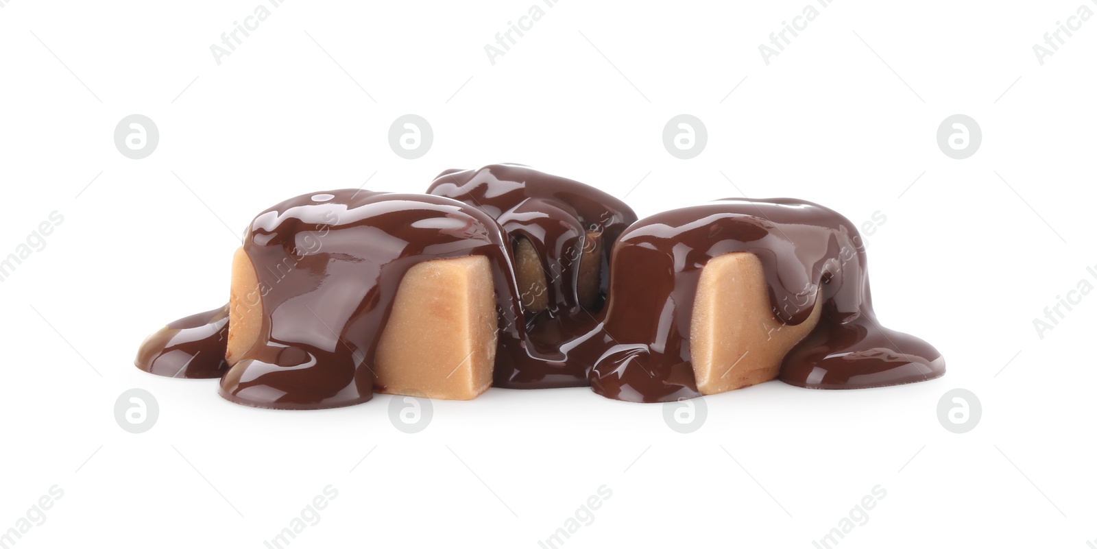 Photo of Delicious caramel candies with melted chocolate isolated on white