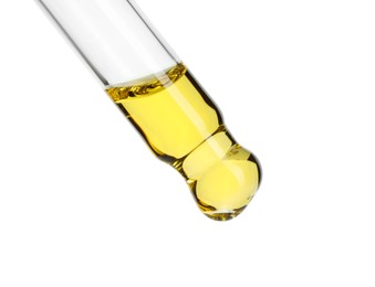 Dripping essential oil from pipette on white background