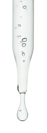 Dripping cosmetic serum from pipette on white background