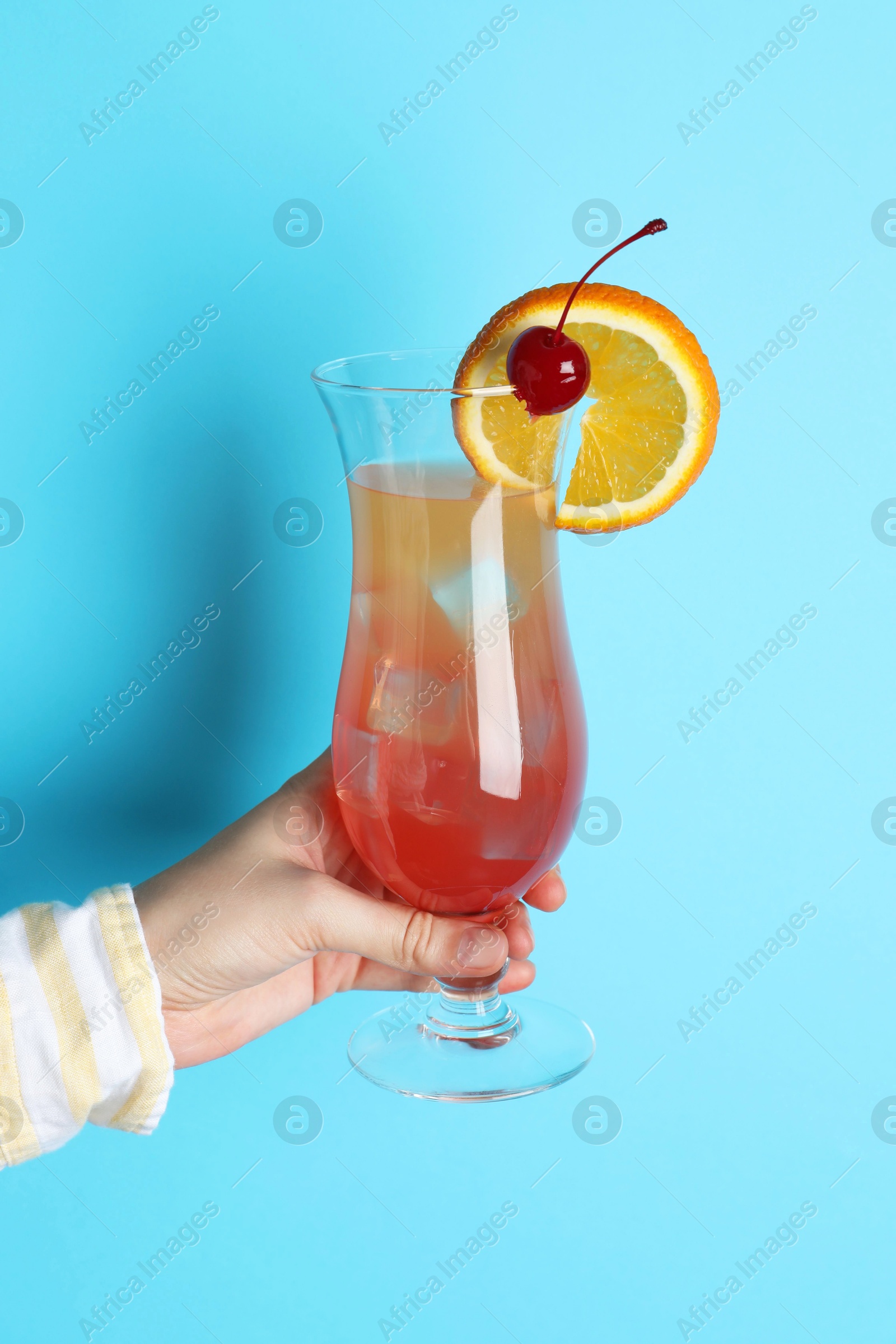 Photo of Woman with glass of refreshing cocktail on light blue background, closeup