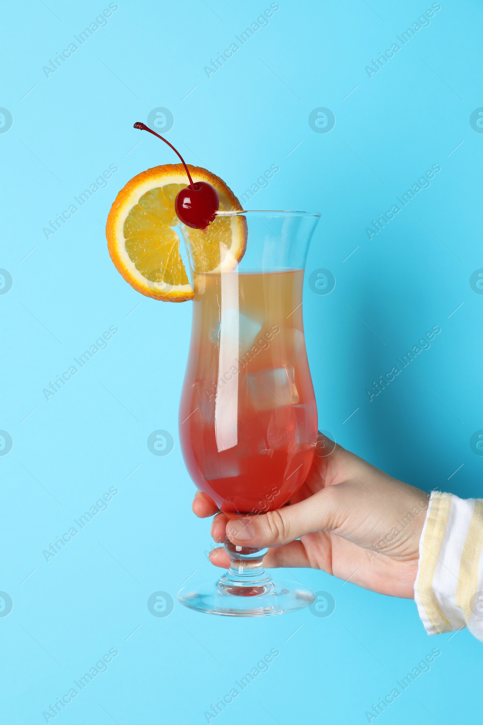 Photo of Woman with glass of refreshing cocktail on light blue background, closeup