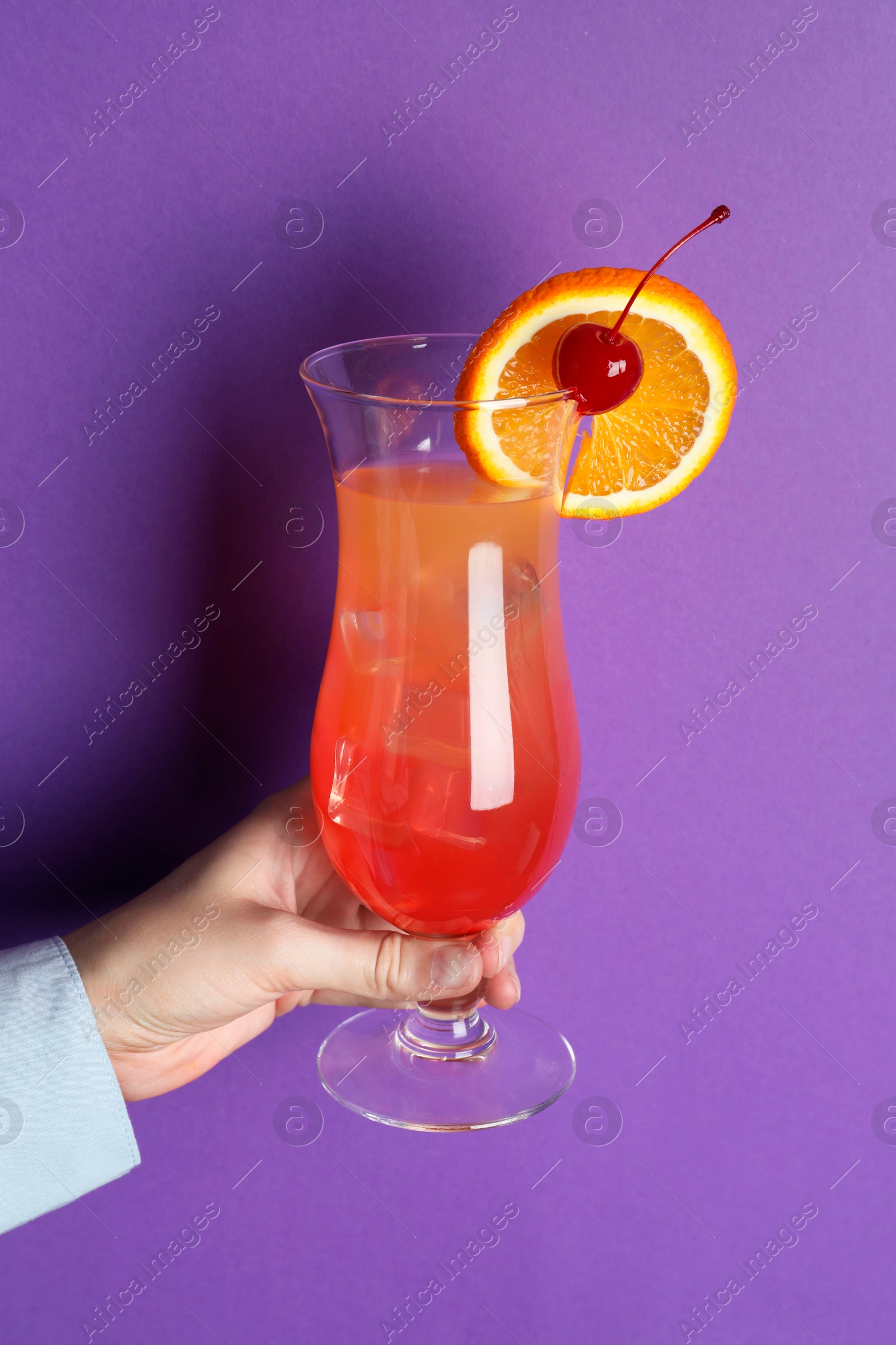 Photo of Woman with glass of refreshing cocktail on purple background, closeup