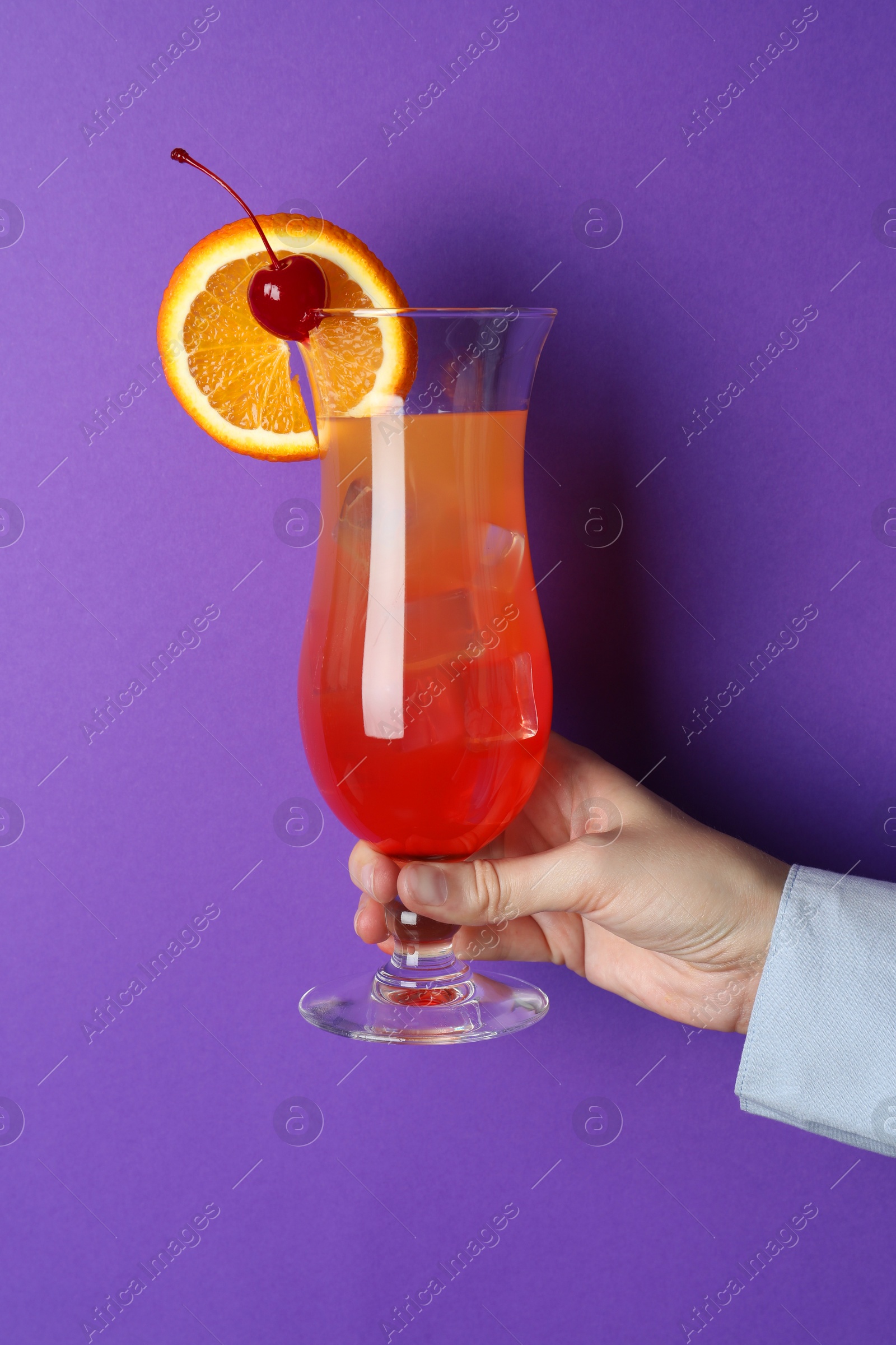 Photo of Woman with glass of refreshing cocktail on purple background, closeup