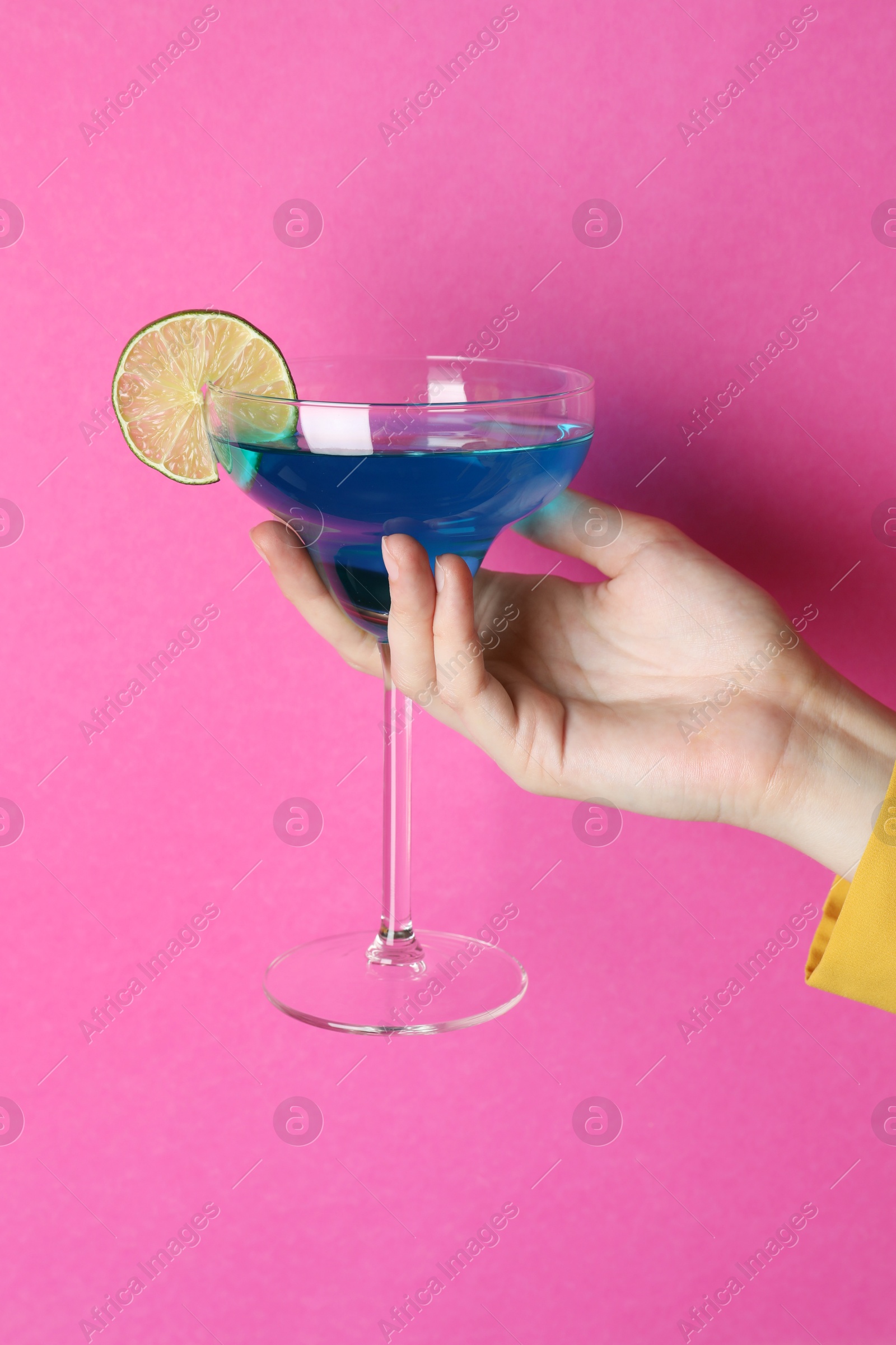 Photo of Woman with glass of refreshing cocktail on pink background, closeup