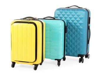 Photo of New yellow and light blue suitcases isolated on white