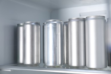 Many cans of beer in refrigerator, closeup