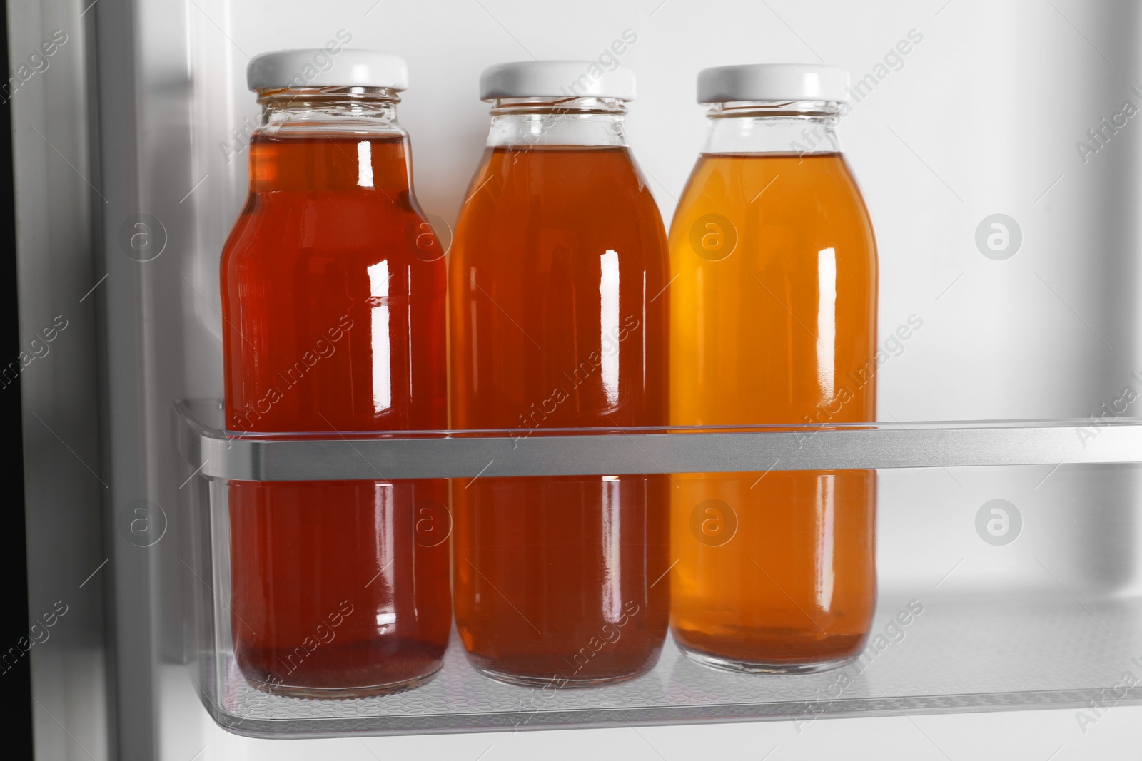 Photo of Many bottles of juice in refrigerator, closeup