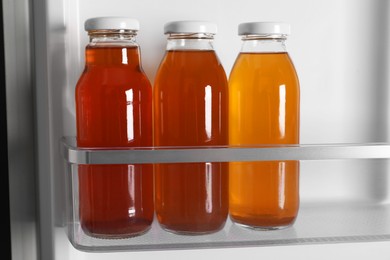 Many bottles of juice in refrigerator, closeup