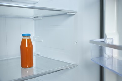 One bottle of juice in refrigerator, space for text