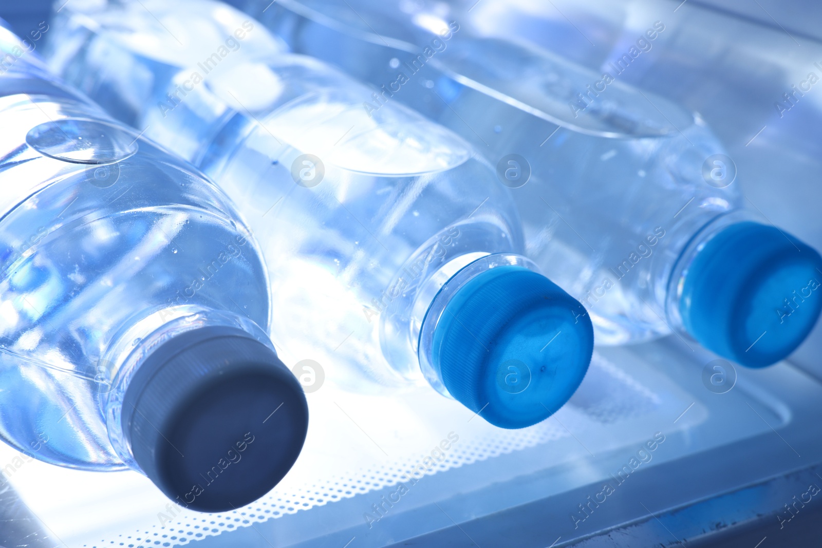 Photo of Many bottles of water in refrigerator, closeup