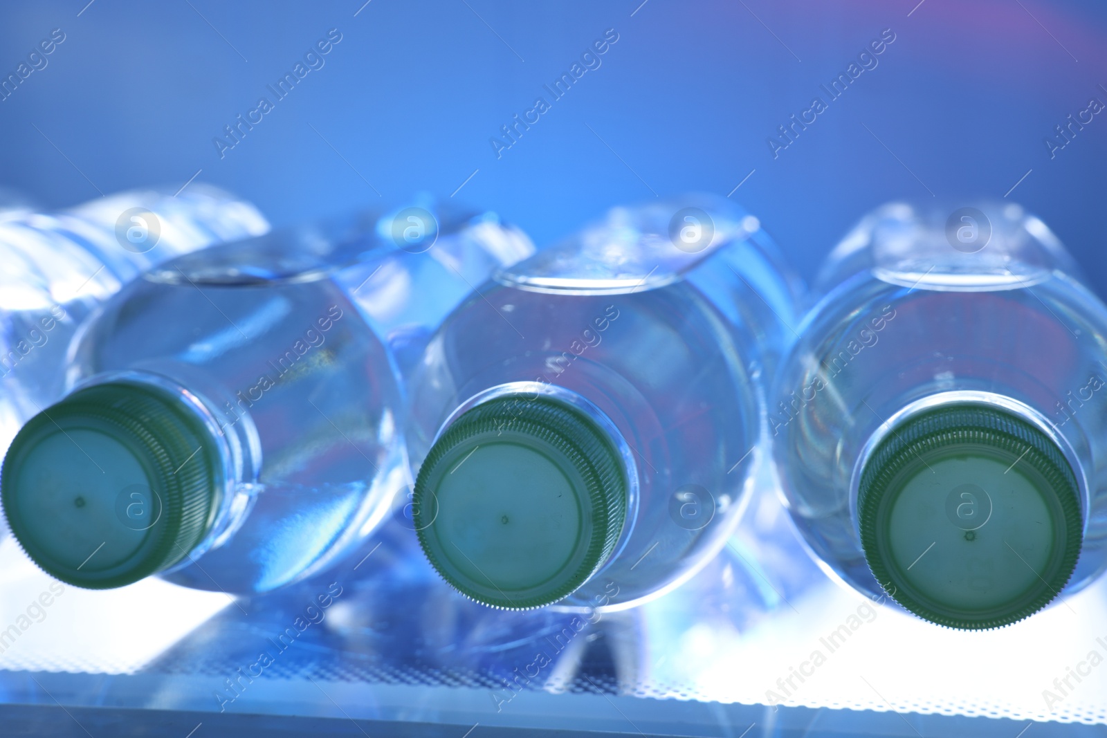 Photo of Many bottles of water in refrigerator, closeup