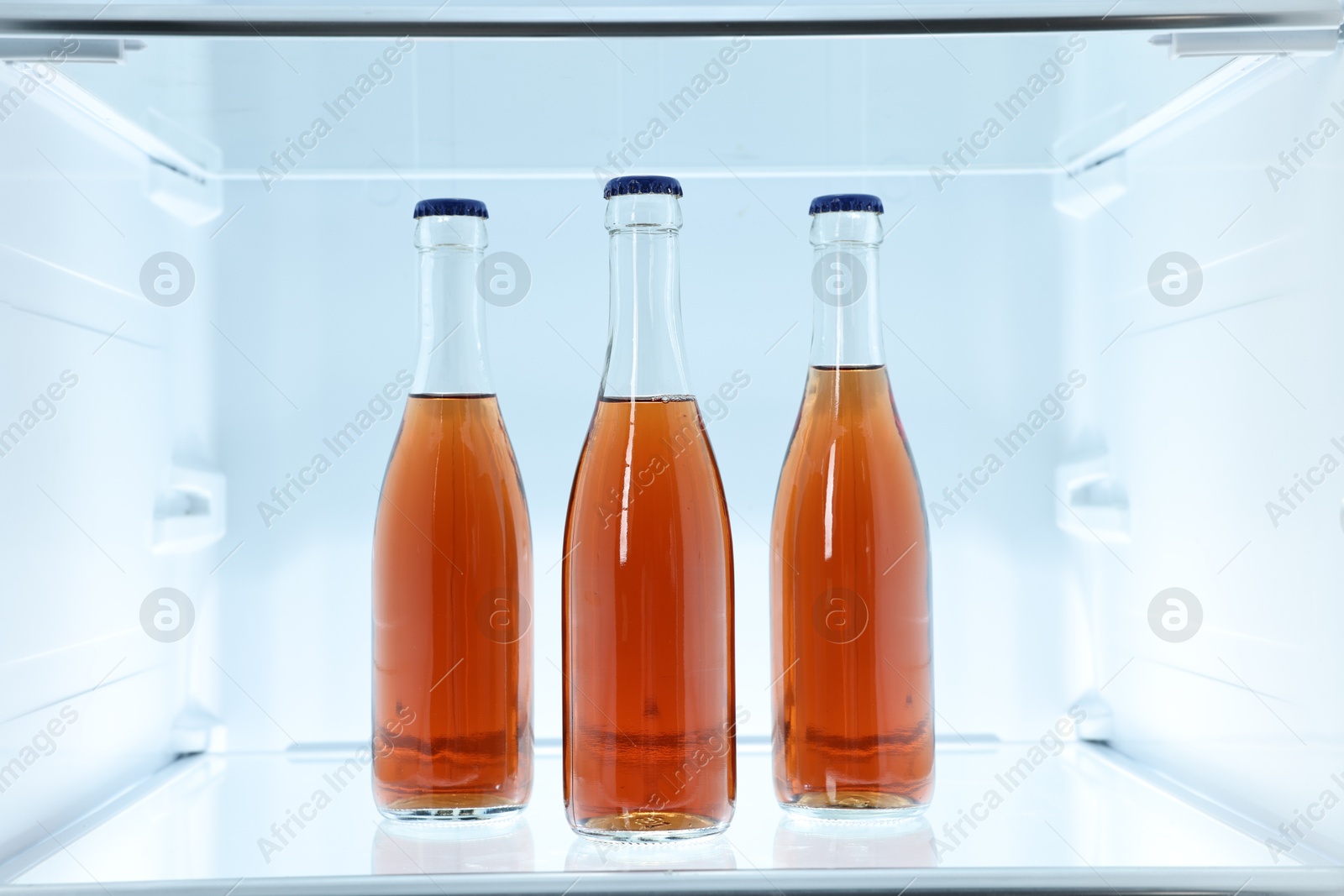 Photo of Many bottles of juice in refrigerator, closeup