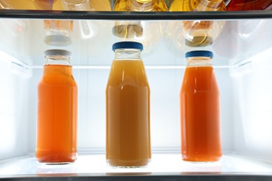 Photo of Many bottles of juice in refrigerator, closeup