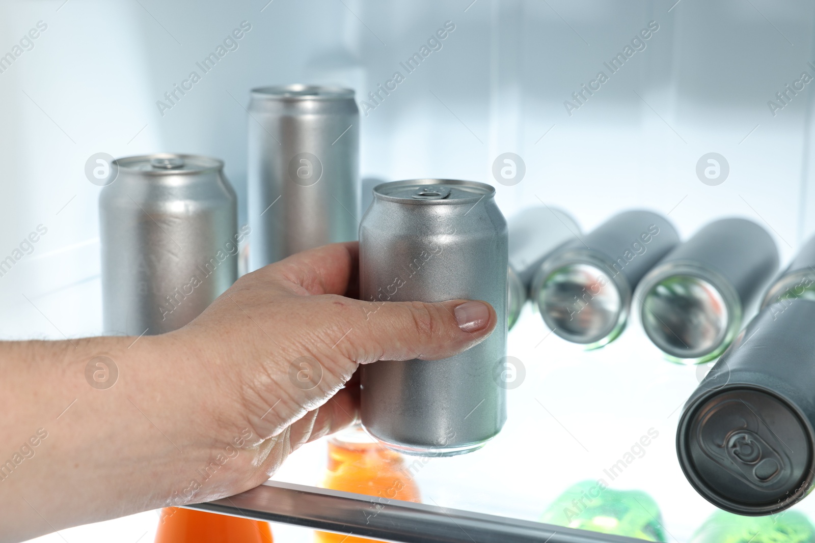 Photo of Woman taking can of beer from refrigerator, closeup