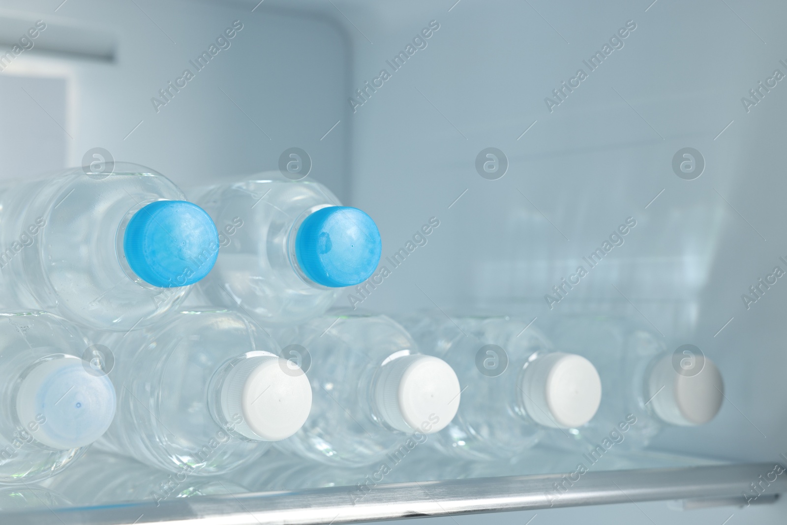 Photo of Many bottles of water in refrigerator, closeup