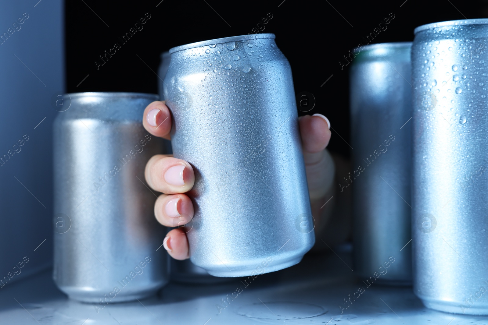 Photo of Woman taking can of beer from refrigerator, closeup