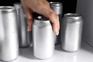 Photo of Woman taking can of beer from refrigerator, closeup