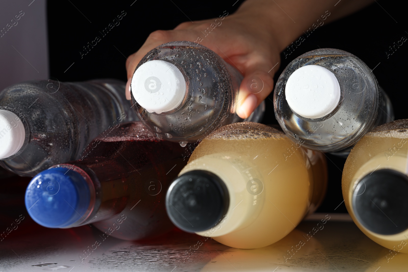 Photo of Woman taking bottle with drink from refrigerator, closeup