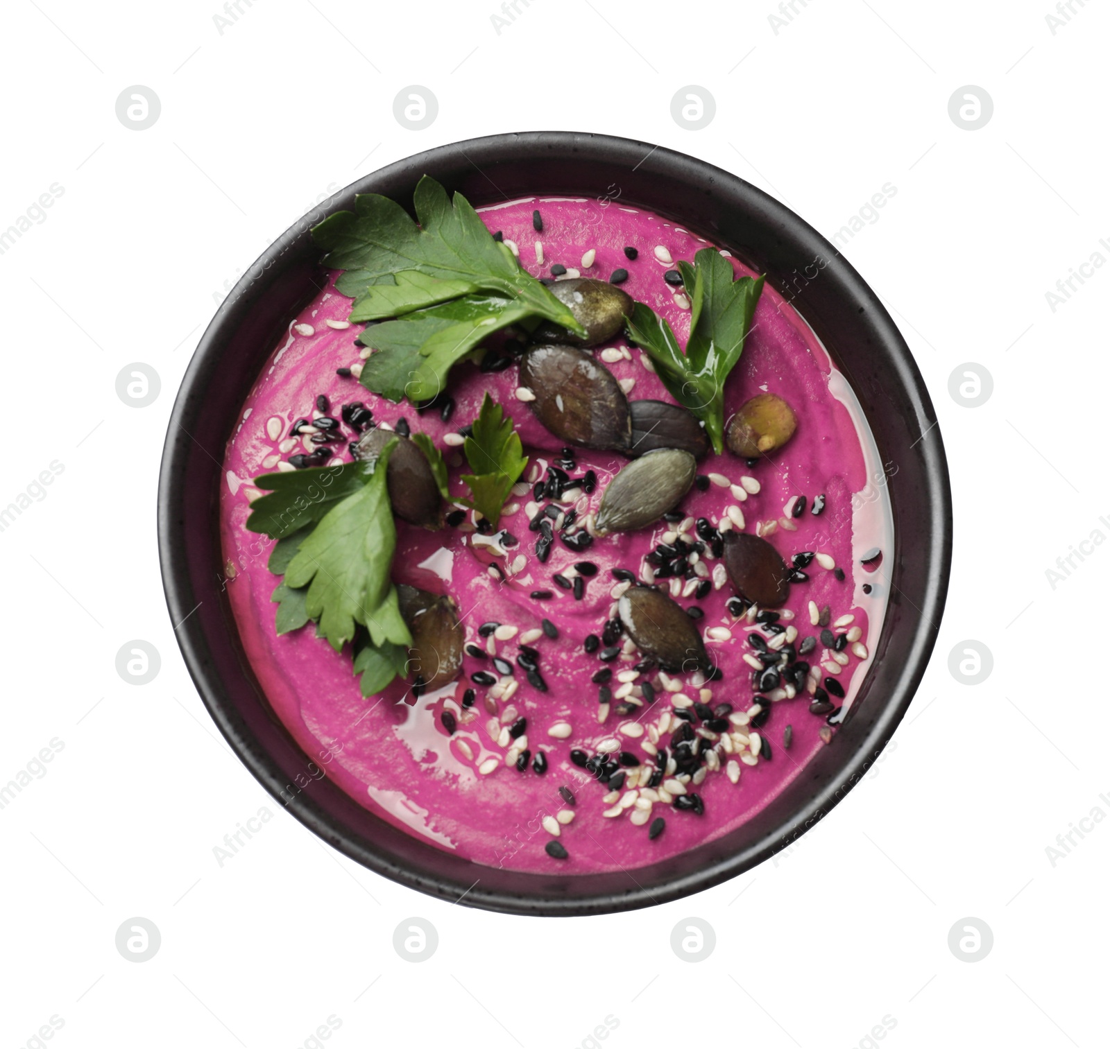 Photo of Tasty beetroot hummus, parsley and sesame in bowl isolated on white, top view