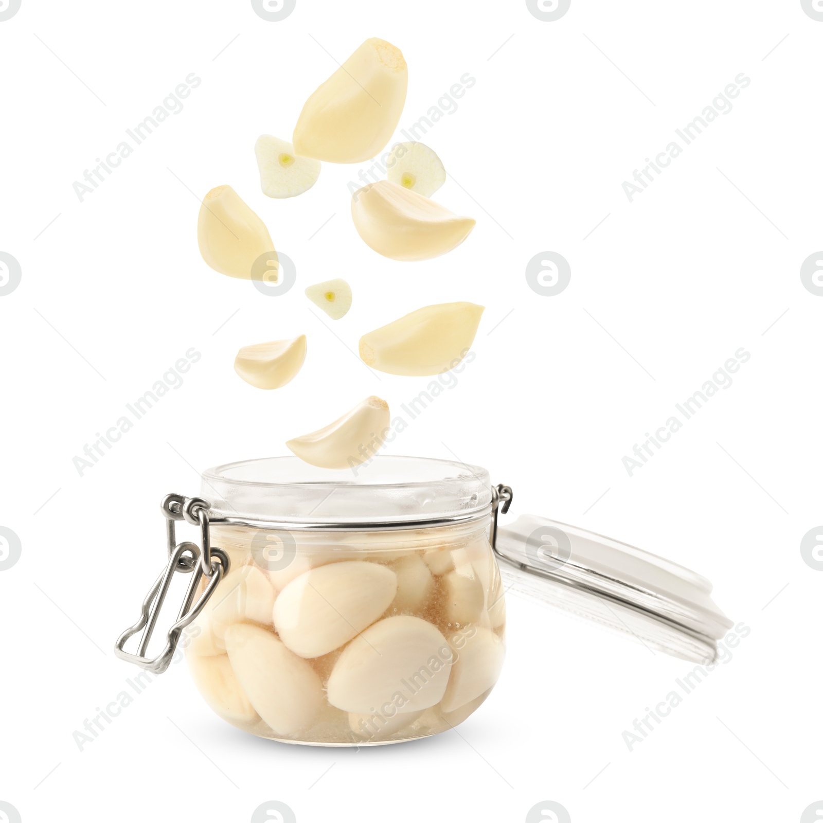 Image of Jar with pickled garlic and cloves falling into it on white background