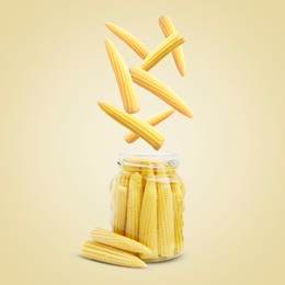 Image of Baby corn cobs falling into jar on light yellow background