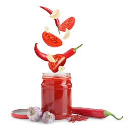 Image of Jar with spicy chili sauce and ingredients falling into it on white background