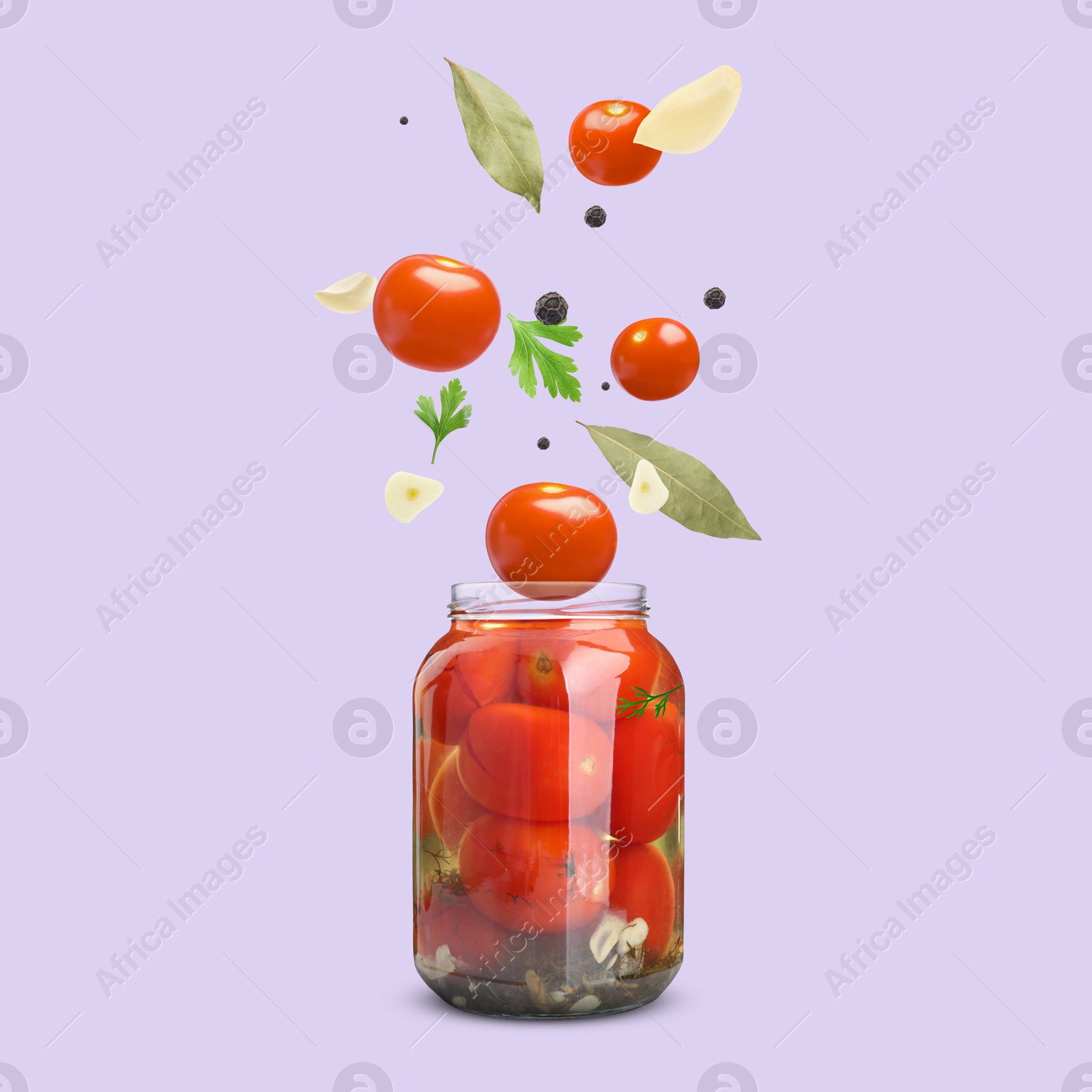 Image of Jar with pickled tomatoes and ingredients falling into it on violet background