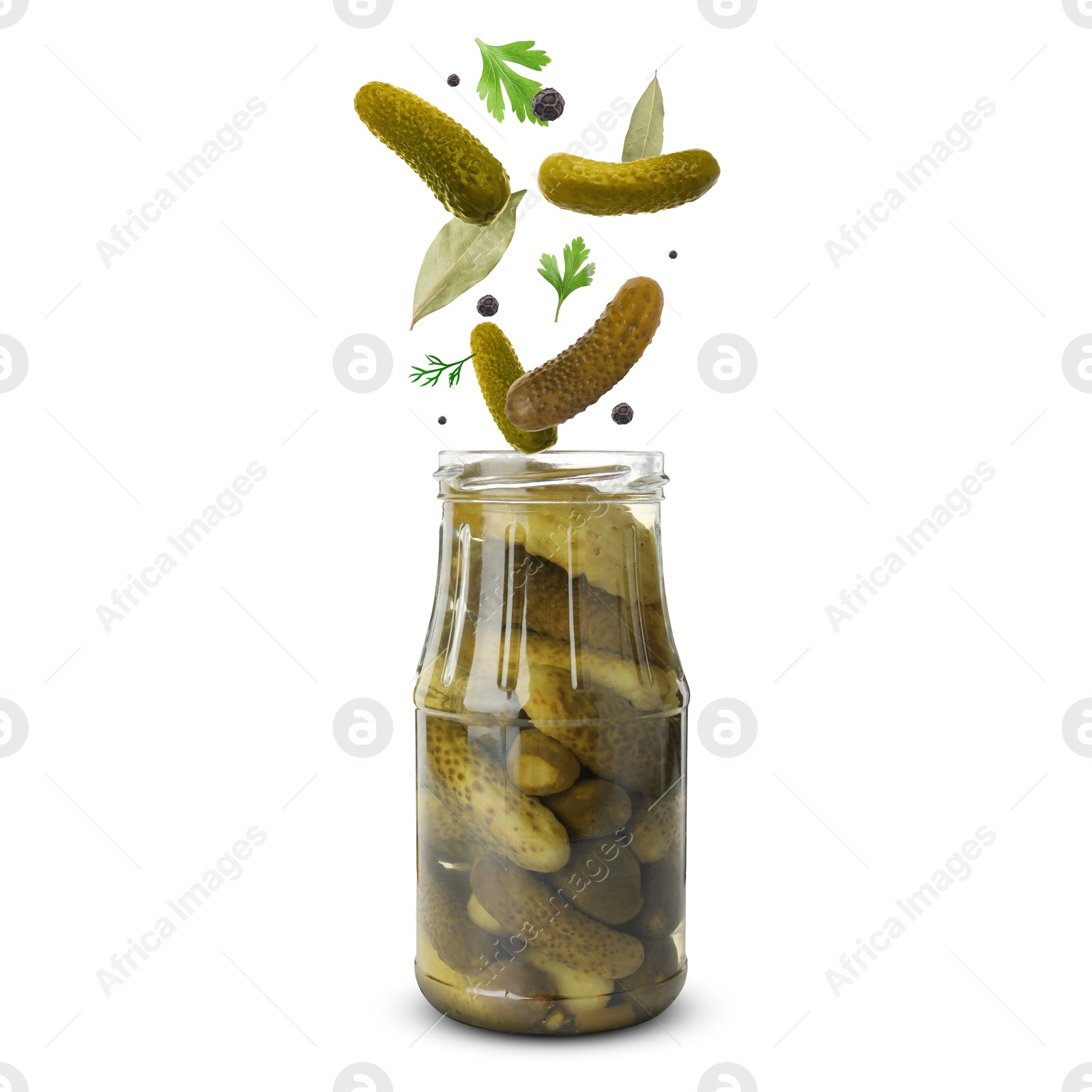 Image of Jar with pickled tomatoes and ingredients falling into it on white background